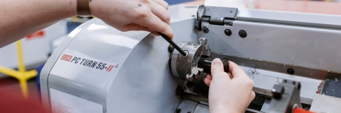 Female student making manual adjustments on large machine.
Technology Facilities Day One - NOT FOR THIRD PARTY - CONSENT