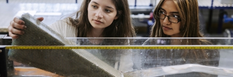 Two female students measuring a project.