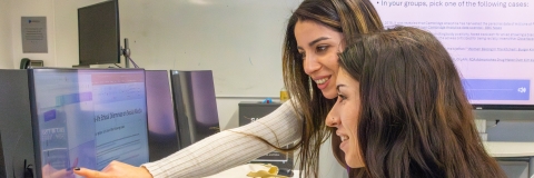 Two women collaborating on a computer 