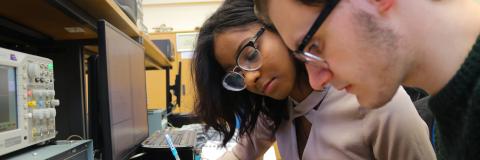 Two students working on an electronic engineering project added