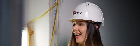 Civil engineering student smiles with floorplan