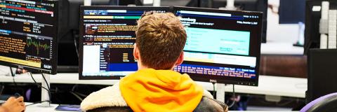  Colombian student sitting at stock trading computer