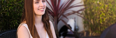 Evangeline Papanicola sitting smiling at camera in white dress