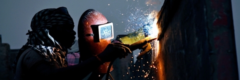 A person in a welding helmet welding