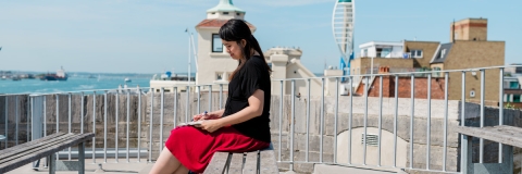 A woman seated on a bench in Old Portsmouth