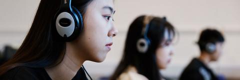 A female Japanese student wearing headphones.