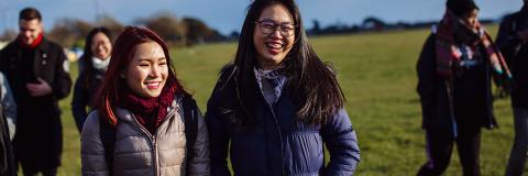 Female student from Malaysia walking on Southsea Common with friends