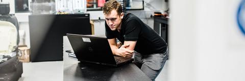 Engineering and management student uses laptop at work