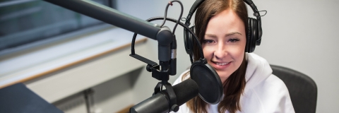 A student in a recording studio wearing headphones