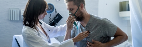 A patient with a respiratory condition being monitored by a medical professional