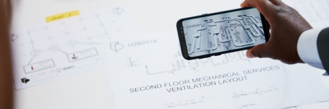 Hand-held mobile device displays augmented reality image of building plan