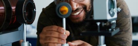 A man with goggles looking at a tech device