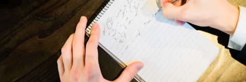 Close up of a notepad while a person takes notes in shorthand