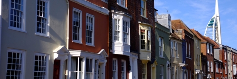 row of georgian style houses on a street with spinnaker tower in the background