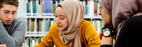 Female student in library looking over paperwork