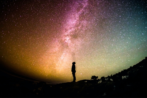 A person looking up at the milky way in the night sky