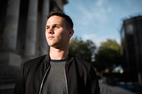 Student looking into distance standing outside the Guildhall