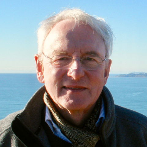 Image of David Stancliffe smiling to camera wearing glasses with sea backdrop