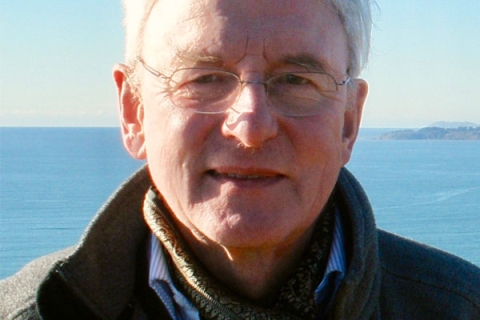 Image of David Stancliffe smiling to camera wearing glasses with sea backdrop