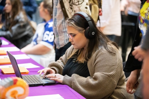 Woman with headphones using a laptop