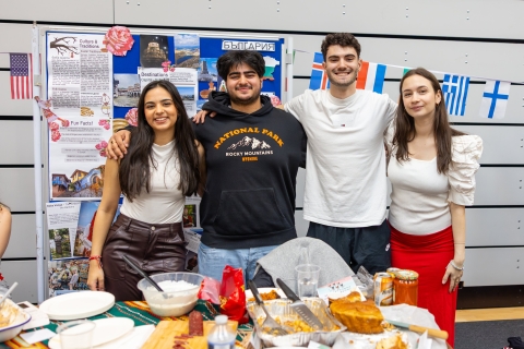 Aleksandra and other Bulgarian students posing behind a table with Bulgarian food
