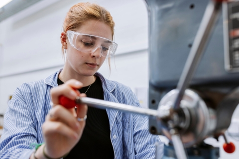 Student operating wood drill in Technology Facilities