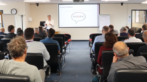 A staff member speaking to a room of people
