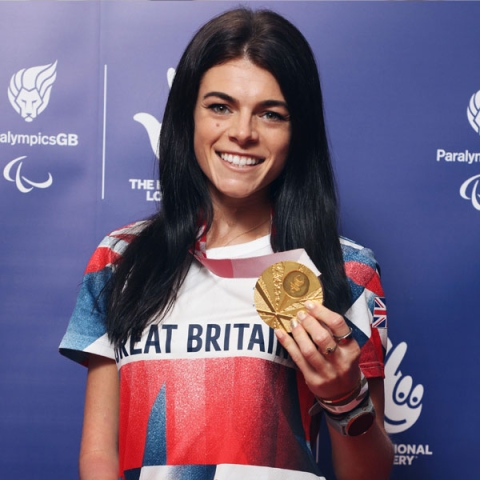 Alumna Lauren Steadman smiling to camera with gold medal