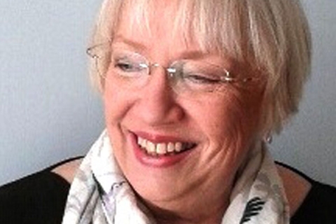 Picture of Maggie Winchcombe smiling to camera wearing glasses