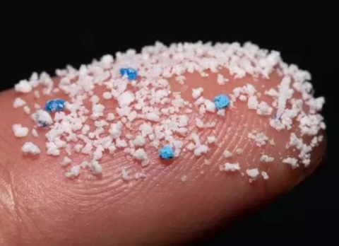 close up image of a finger covered with tiny pieces of plastic