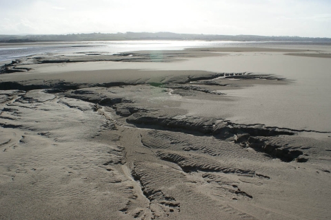 A mudflat with the sea in the distance