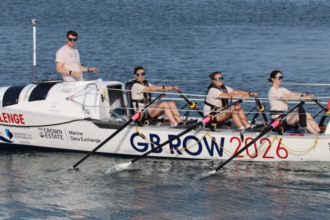 An ocean rowing boat with crew rowing 