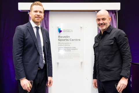 Paul Tilley and Filippo Antoniazzi standing in front of plaque at Ravelin Sports Centre official opening. Paul is wearing a suit and Filippo is wearing a black shirt.