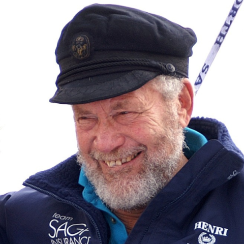 Image of Sir Robin Knox-Johnston smiling to camera wearing cap and coat