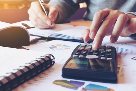 man using calculator at desk