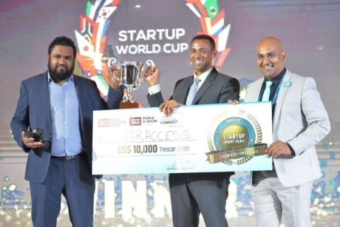 Picture of Melwyn receiving large cheque during Startup World Cup