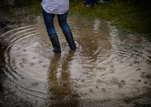A person wearing wellies stood in a flooded area