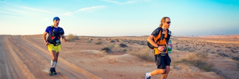 Two runners competing in extreme heat in the desert