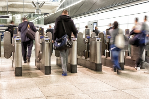 Passengers passing through automatic ticket barriers at underground station