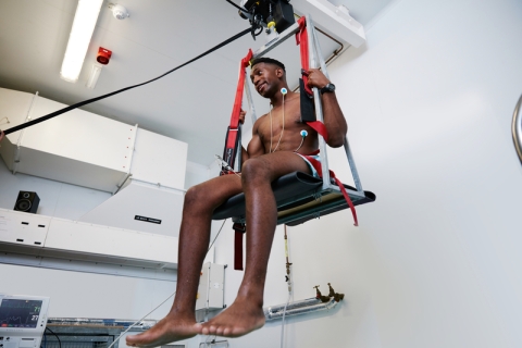 Student sitting in a harness, participating in sports science test