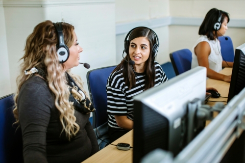 two female students speaking with headsets