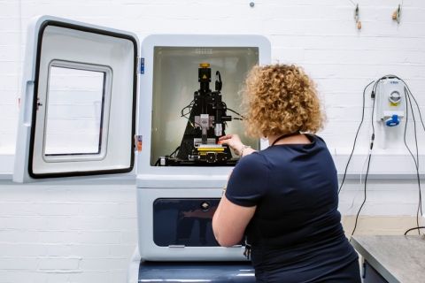 A female member of staff adjusting imaging equipment for project