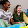 Two students laughing together in halls 