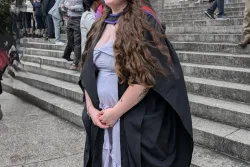 Student wearing graduation cap and gown.