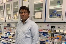Photo of Binuraj Menon standing in a lab