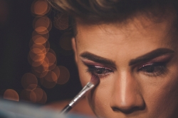 Person putting on eye make up - Photo by Jesús Boscán on Unsplash