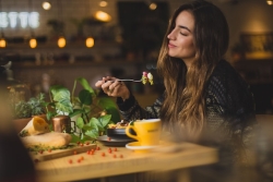 Woman smelling her dinner as she eats