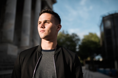Student looking into distance standing outside the Guildhall