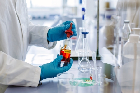 Hands holding a vial in a lab