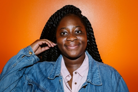 A woman with long twists, smiling